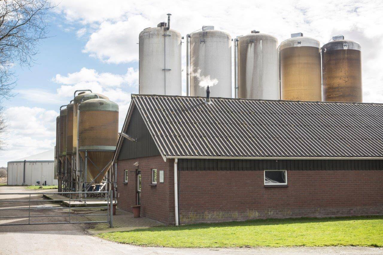 De silo's voor de opslag van natte bijproducten en aanvullende voeders. Op de achtergrond staat de nieuwe mestopslag. 